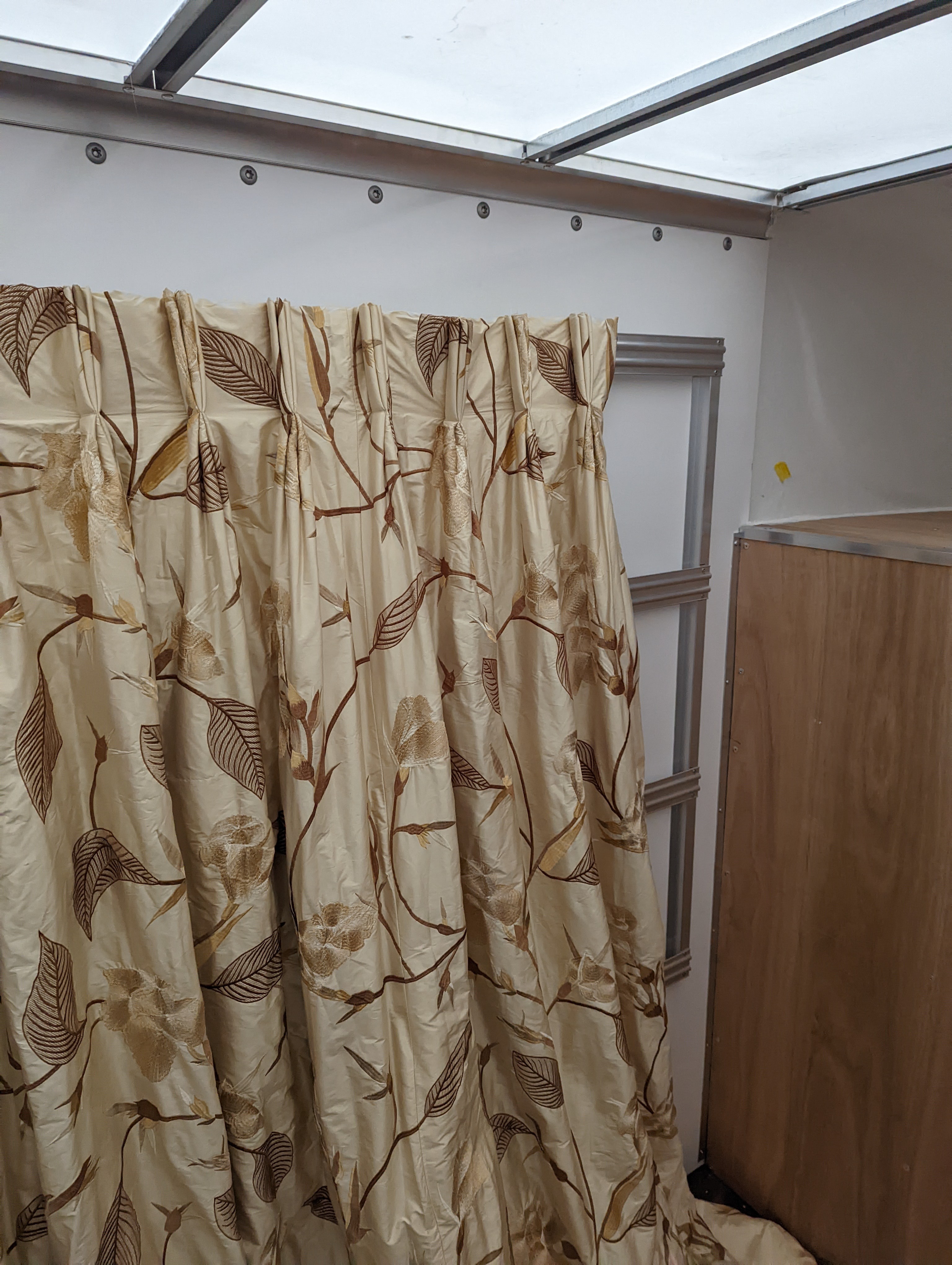 A pair of floral lined curtains. Approximate measurements: Width of top 230cm, Width of bottom 420cm Length 250cm